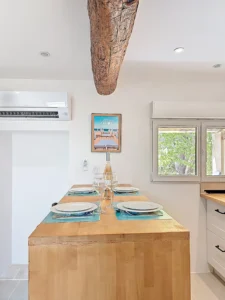 Cuisine équipée avec table repas, poutre apparente et climatisation dans une villa en Provence